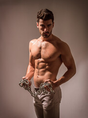 Photo of a shirtless man wearing a chain necklace