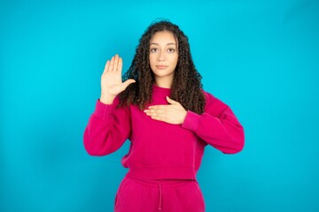 Fototapeta premium Young beautiful teen woman Swearing with hand on chest and open palm, making a loyalty promise oath