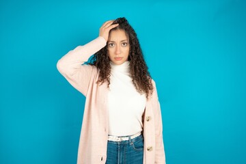 Embarrassed beautiful teen girl with shocked expression, expresses great amazement, Puzzled model poses indoor