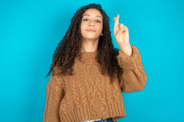 beautiful teen girl wearing brown knitted sweater pointing up with fingers number ten in Chinese...