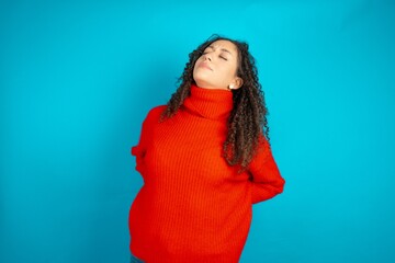 beautiful teen girl wearing red knitted sweater got back pain