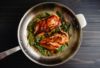 Chicken Breasts with Fresh Sage in a Stainless Steel Skillet: Marinated chicken breasts and fresh...