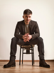 Photo of a businessman seated on a chair wearing a suit