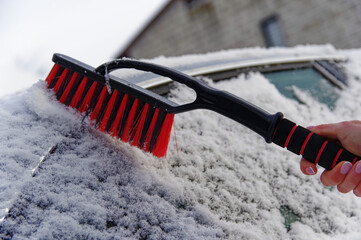Odśnieżanie auta, atak zimy, zimowa aura i śnieżyca.
