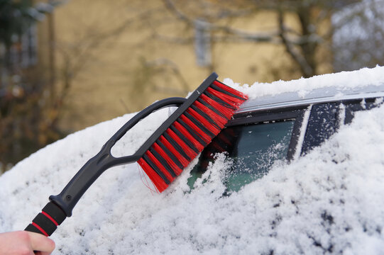 Odśnieżanie auta, atak zimy, zimowa aura i śnieżyca.
