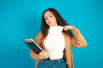 beautiful arab student carries notebooks stressed, anxious, tired and frustrated, pulling shirt neck, looking frustrated with problem