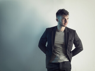 Naklejka premium Photo of a man posing in front of a white brick wall