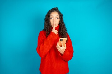 beautiful teen girl wearing red knitted sweater holding modern gadget ask not tell secrets