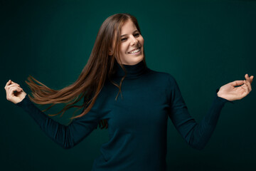 Young pretty woman with long brown healthy hair on green background