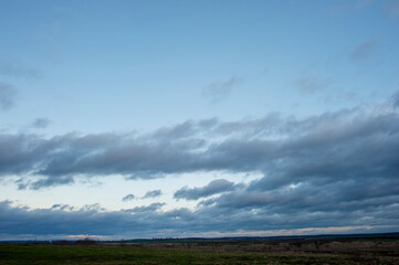 Panorama of dawn fire in the sky above the natural pasture. Golden red clouds just before sunrise. Picturesque landscape at sunrise. Beauty in nature
