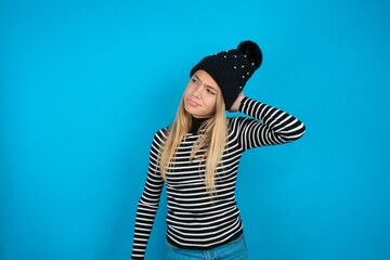 Teen caucasian girl wearing striped sweater and woolly hat confuse and wonder about question....