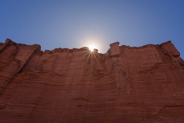 Naklejka premium Muro de piedra color rojo con sol con forma de estrella - Parque Nacional Talampaya - La Rioja - Argentina