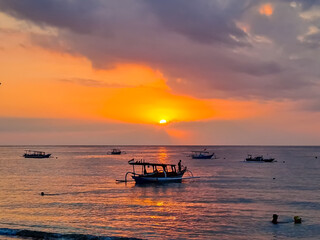 Silhouette view of traditional boats in the beach during sunset. Nipah beach, Indonesian tourism object