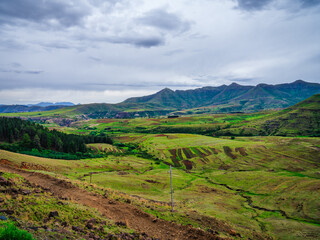 Fototapeta na wymiar Agricultural land in a valley surrounded by mountain peaks, the mountain kingdom of Lesotho