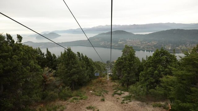 Taking the chairlift down the mountain in Bariloche, Patagonia Argentina.. Beautiful green forest and Nahuel Huapi lake view.	