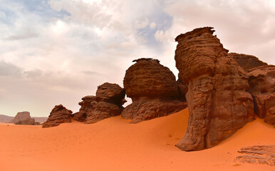 Fototapeta na wymiar Rock formations in Tadrart Rouge, Tassili N'Ajjer National Park. Sahara desert, orange sand and rocks. Holidays and travel in Algeria. Sahara, Algeria, Africa.