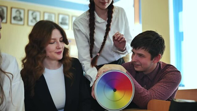 Students in physics class spin Newton's colorful wheel.