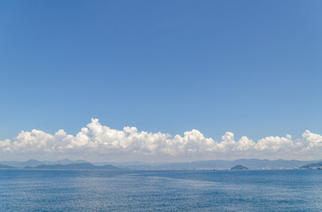 夏の雲の目立つ空と粭島から見た周南コンビナート