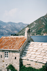 Fototapeta na wymiar Ancient stone church of Our Lady of the Angels with a belfry on the roof. Donji Stoliv, Montenegro