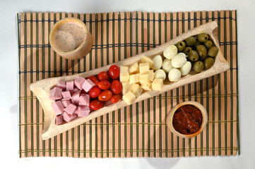 portion of cold snacks cheese ham olive oil