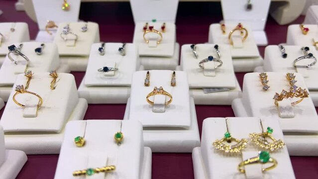 Gold rings and earrings are on the showcase of a jewelry store