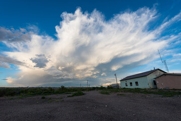 Ragged Storm Clouds Fill The Evening Sky Over A Dirt Road