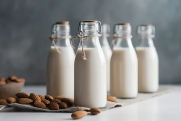 Fotobehang Bottled almond milk on a bright backdrop. Generative AI © Yseult