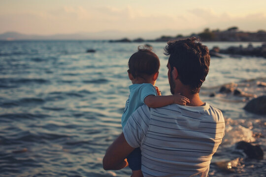 Un papa et son fils de dos, faisant face à la mer. Nature, eau, extérieur, horizon. Famille, enfant, père, garçon. Pour conception et création graphique.