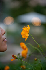 Woman smelling orange flower