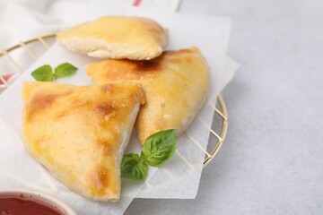 Delicious samosas and basil on light grey table, space for text