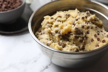 Chocolate chip cookie dough in bowl on table, closeup