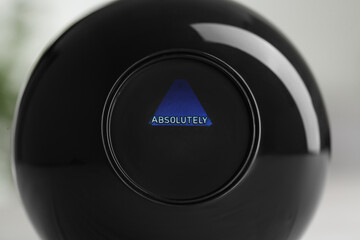 Magic eight ball with prediction Absolutely on light background, closeup