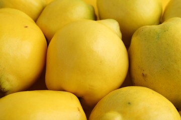 Delicious ripe quinces as background, closeup view