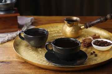 Turkish coffee. Freshly brewed beverage served on wooden table, closeup