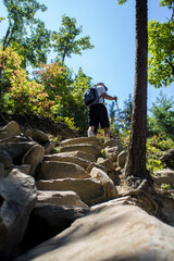 A fit elderly caucasian male hiking at the top of a rocky trail.