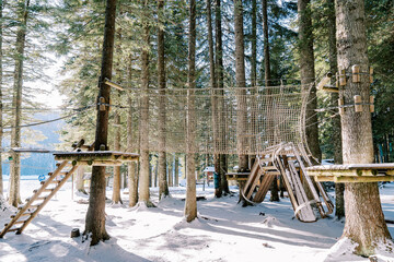 Endurance mesh bridge in amusement park in winter forest