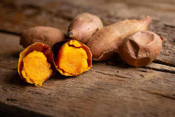 Baked orange texture of sweet potato on wooden table background for Roasted and Baked of Japanese...