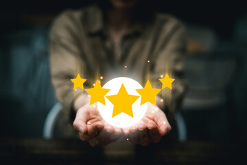 Service rating concept, Hand of a woman holding five best gold star review scores, Customer evaluation feedback, Positive Review for Client's Satisfaction Surveys, giving a five-star rating.
