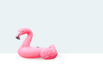 Pink pool plastic inflatable flamingo with light blue background