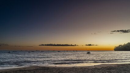 Twilight after sunset on a tropical island. The blue-purple sky is highlighted in orange. Light...