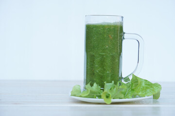 Green smoothie organic herbal vegetables in glass, outdoor background. Concept, healthy beverage...