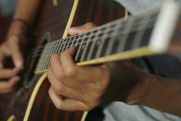 Close-up man playing acoustic guitar