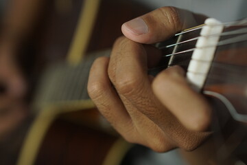 Close-up man playing acoustic guitar