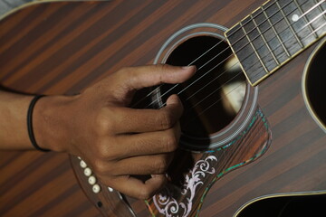 Close-up man playing acoustic guitar