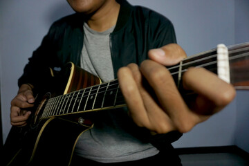 Close-up man playing acoustic guitar