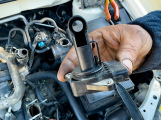 Mechanic holding Intake manifold absolute pressure sensor (MAP sensor ) in hand for examining and...