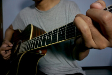 Close-up man playing acoustic guitar