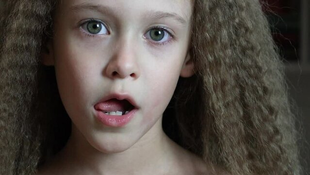 Cute little girl smiles and shows her fallen front milk teeth. Teeth growth. Close-up. Portrait of a 6-year-old rebec