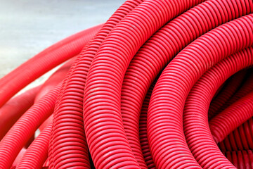 Red plastic corrugated pipe for installation of communications and electrical cables.