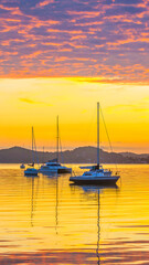 Aerial sunrise over the water with boats and clouds